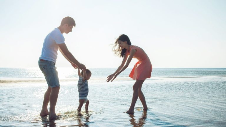 Dad baby and mom on the beach in the water walking x